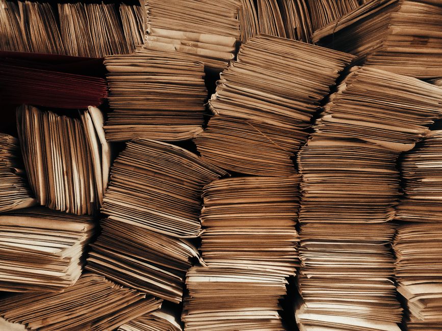 Stacked legal documents and tabbed file folders on a desk